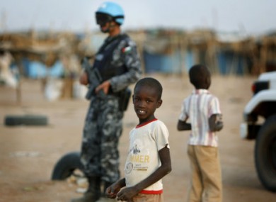 File photo of Sudanese children and a UN peacekeeper bearing a Jordanian flag on his uniform.