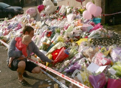 A man lays flowers at a memorial for Tia Sharp near her grandmother's home