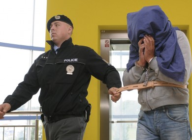 A policeman leads a man accused in the case of illegal alcohol to the court in Zlin, Czech Republic, 250 kilometres east of Prague on Friday