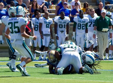 Devon Walker, bottom right, and Tulane team-mate Julius Warmsley (92) tackle Tulsa's Kenny Welcome, bottom left.