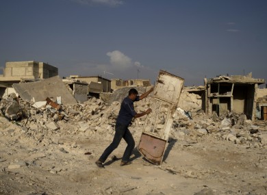 A Syrian man pushes a door away from the rubble of houses destroyed in a government airstrike, in the Syrian town of Azaz on Friday.
