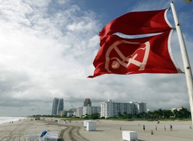 Red flags fly from a lifeguard station as Hurricane Sandy passes offshore to the east, Friday, Oct. 26, 2012, in Miami Beach.