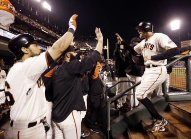 San Francisco Giants' Hunter Pence is congratulated in the dugout after scoring during the seventh inning.