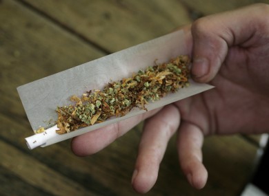 A user demonstrates rolling a joint with tobacco and marijuana in a coffee shop in Amsterdam (File photo)