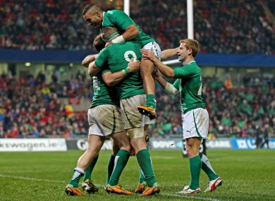 Simon Zebo leaps onto a mob of celebrating Irish players.