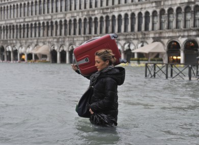 A tourist crosses flooded St. Mark's Square in Venice, Italy, today.