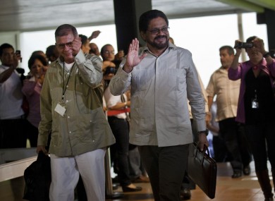 Ivan Marquez, right, and Ricardo Tellez, members of the negotiation team for Colombia's Revolutionary Armed Forces of Colombia, or FARC, wave as they arrive for peace talks in Havana, Cuba