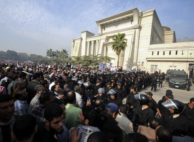 Riot police form a cordon as several thousand supporters of Islamist President Mohammed Morsi surround the Supreme Constitutional Court today.