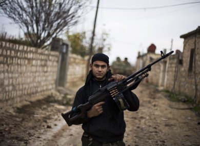 A Free Syrian Army fighter poses as he carries his weapon in the northern province of Aleppo, Syria.
