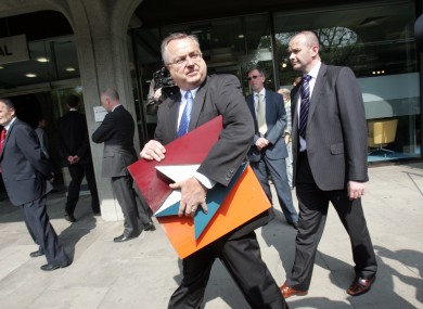 IBRC chief executive Mike Aynsley carries the old Anglo logo away from the bank's headquarters on St Stephen's Green.