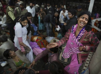 An Indian woman weeps as she and other family members mourn next to the body of a relative who was killed in the stampede.