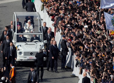 Pope Benedict XVI waves from his pope-mobile as he is driven through the crowd during his last general audience in St. Peter's Square.