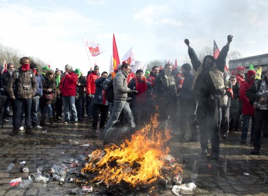 Union members light a fire during a demonstration outside an EU summit in Brussels on Thursday