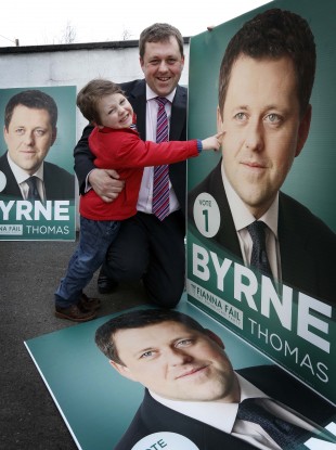 Fianna Fáil Senator Thomas Byrne and Tomás (aged 4) inspect the Fianna Fáil by-election photos near Ashbourne yesterday evening.