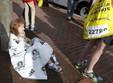 A runner sits alone following the explosion at the Boston Marathon yesterday.