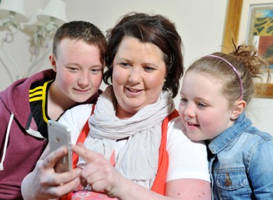 Karen McDermott, a mother of two from Clonakilty, who received a life saving heart transplant in August 2012 with her two children Nicola and Shane looking at the Donor Ecard Phone App.