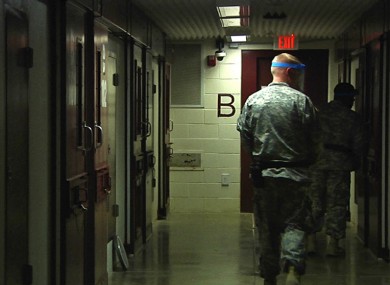 April 18, 2013 video frame grab reviewed by the U.S. military, soldiers walk past detainees' cells during early morning prayer at Guantanamo Bay Naval Base