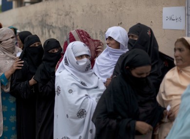 Women voters stand in a queue outside a polling station in Islamabad