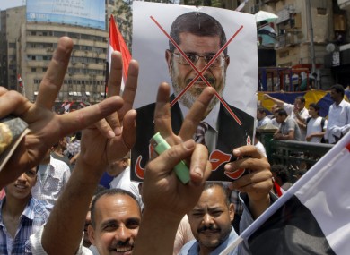 Egyptian protesters flash v signs as they raise an anti-Islamist president Mohammed Morsi poster during a demonstration in Tahrir Square in Cairo today.