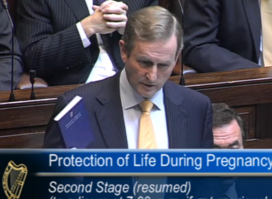 Taoiseach Enda Kenny with a copy of the constitution during the Dáil debate