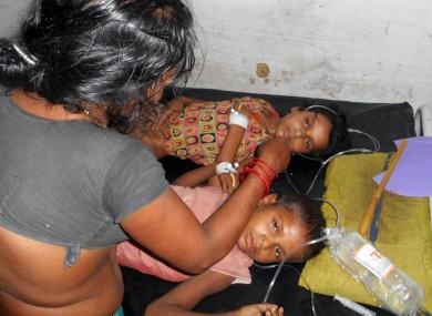 Schoolchildren receive treatment at a hospital after falling ill soon after eating a free meal at a primary school, Tuesday, July 16, 2013.