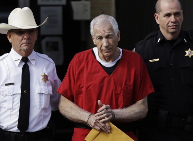File: Jerry Sandusky, centre, is taken from the Centre County Courthouse by Centre County Sheriff Denny Nau, left, and a deputy