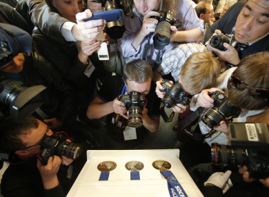 Photographers take images of the Sochi 2014 Olympics medals.