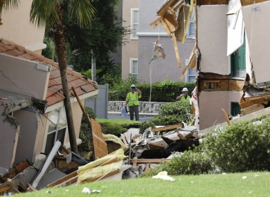 Inspectors look over damage to buildings caused by the sinkhole