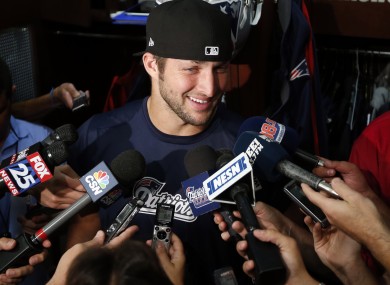 All smiles: New England Patriots quarterback Tim Tebow speaks to media in the locker room.