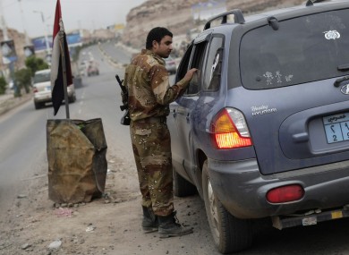 A Yemeni soldier inspects a car at a checkpoint on a street near the US embassy in Sanaa, Yemen