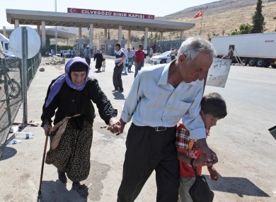Syrian refugees arrive at the Turkish Cilvegozu gate border earlier today.