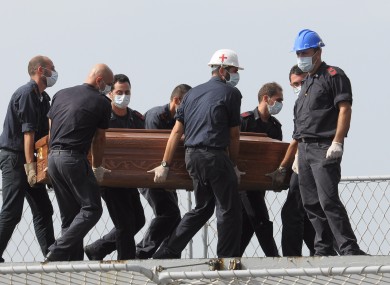 The casket of one of the migrants who died when their boat capsized in the Canal of Sicily is carried aboard an Italian navy ship on Saturday.