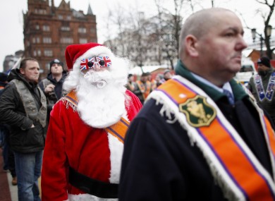 A demonstrator dressed as Santa walks with participants in today's march.