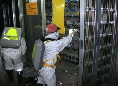 A worker measures water levels at the number one reactor of the Fukushima Daiichi Nuclear Power Station.