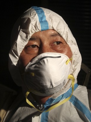 A worker wears mask as he spraying disinfectant in a live poultry market in Banchiao, New Taipei City, Taiwan.