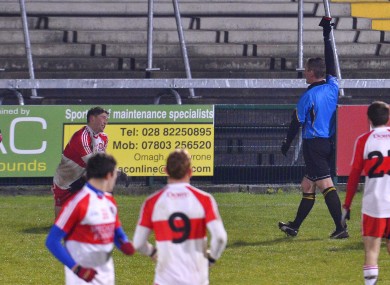 Derry's Declan Mullan is shown a black card by referee Brendan Rice.