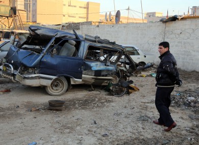 An Iraqi man inspects a minibus damaged in a car bomb attack in Baghdad earlier this month.