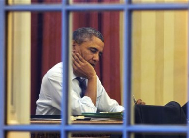 President Barack Obama works at his desk in the Oval Office.