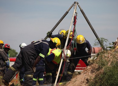 Emergency rescue workers attempt to free the trapped illegal miners.