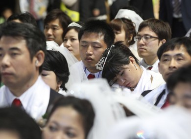 A newly-married couple takes a nap in a mass wedding ceremony at the CheongShim Peace World Center in Gapyeong, South Korea.