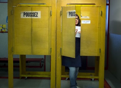 A Swiss voter leaves a polling box in Geneva yesterday