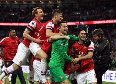 Arsenal's goalkeeper Lukasz Fabianski is mobbed by his team-mates after they win the game on penalties.