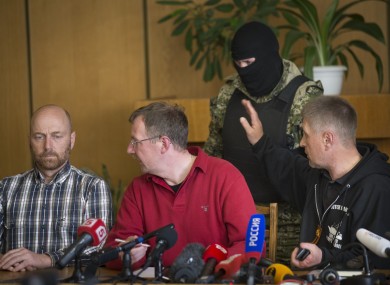 Vacheslav Ponomarev, the self-proclaimed mayor of Slovyansk, right, speaks to a pro-Russian gunman, as two of foreign military observer, one of them Axel Schneider of Germany, center, look to each other during a press conference in city hall, of Slovyansk.