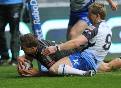 Ashley Beck crosses for the Ospreys despite the attention of Kieran Marmion.