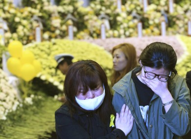 Relatives of a passenger aboard the sunken ferry Sewol weep as they pay tribute to the victims of the ship at a group memorial altar in Ansan, South Korea