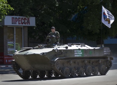 A pro-Russian militant sits atop an armored personal carrier.