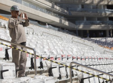 A worker takes a picture at the Itaquerao, one of six stadiums that were supposed to be finished by the end of 2013, but a crane collapse that killed two workers in November caused delays (File photo)