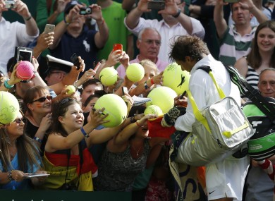 Rafael Nadal sings autographs after defeating Martin Klizan of Slovakia.