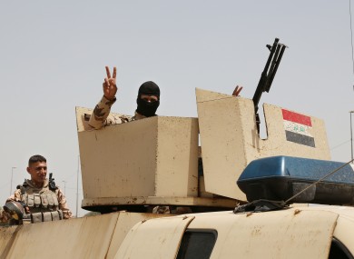 An Iraqi soldier flashes a V for victory sign in Baghdad.
