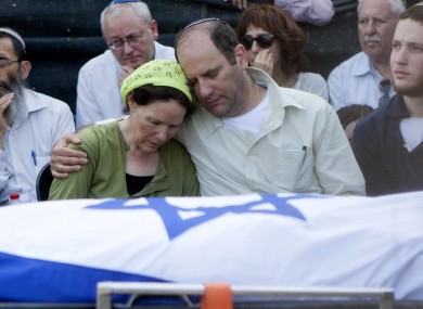 Avi and Rachel Fraenkel embrace during the funeral of their son, Naftali.